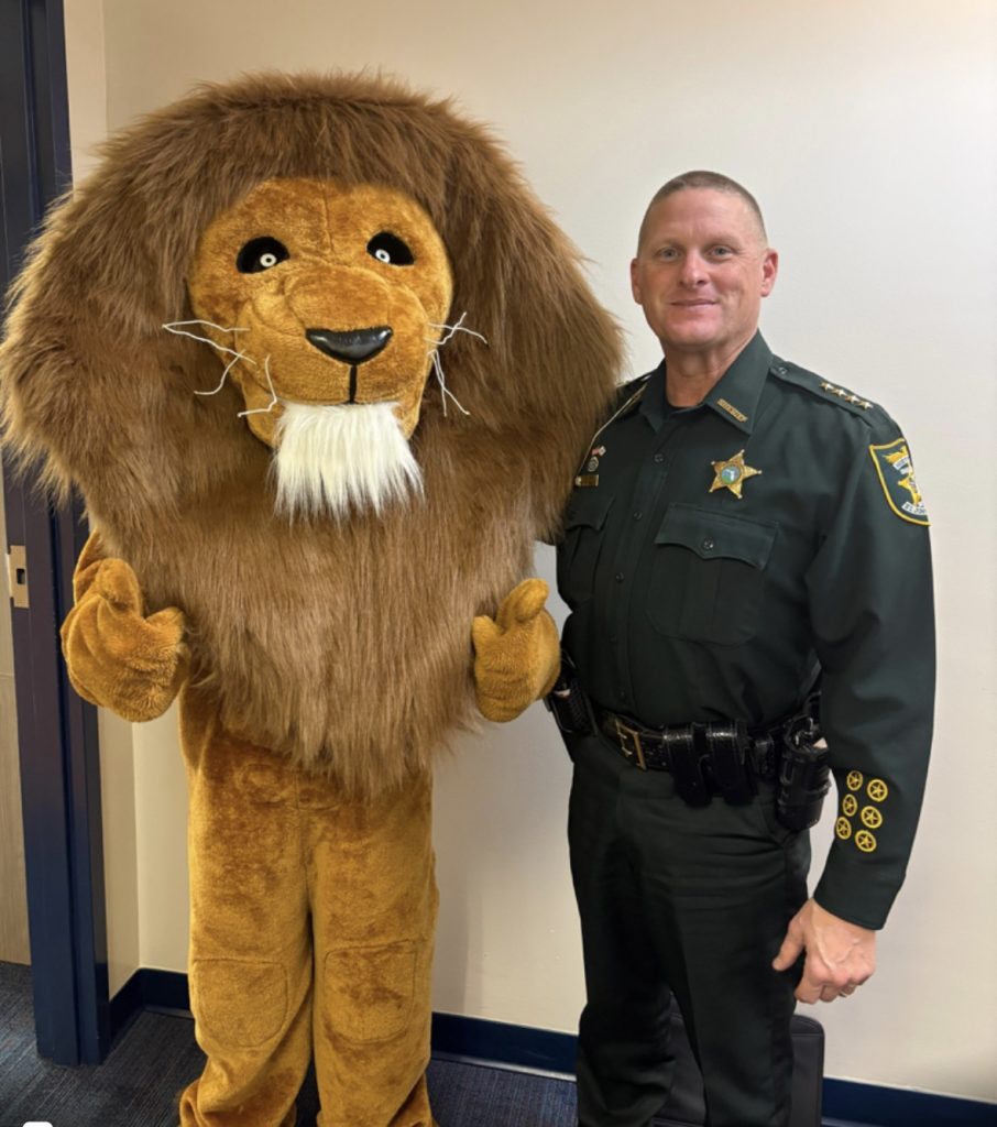 The Landrum Middle School mascot joins St. Johns County Sheriff Hardwick during the inaugural Lion Fest, which featured a safety talk and community pep rally. Photo courtesy Landrum Middle School PTO