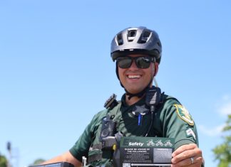 Cpl. Michael Ettel displays the St. Johns County Sheriff’s Office e-bike safety card, which outlines the differences between electric bicycle classes and illegal e-motos. Photo courtesy St. Johns County Sheriff's Office