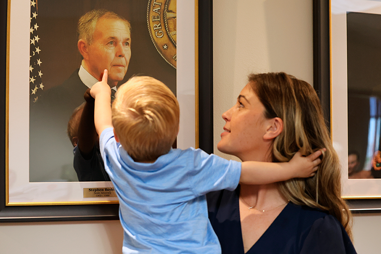 A young family member points to the portrait of former State Attorney Stephen Boyles during the dedication ceremony held at the S. James Foxman Justice Center. Photo by Haley Harrison, Office of State Attorney R.J. Larizza