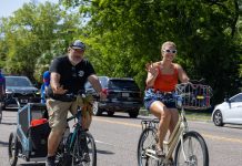 Cyclists wave to onlookers as they ride together during the Duval Day Bike Tour. Photo by Emily Delaney
