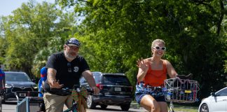 Cyclists wave to onlookers as they ride together during the Duval Day Bike Tour. Photo by Emily Delaney