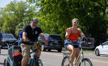 Cyclists wave to onlookers as they ride together during the Duval Day Bike Tour. Photo by Emily Delaney
