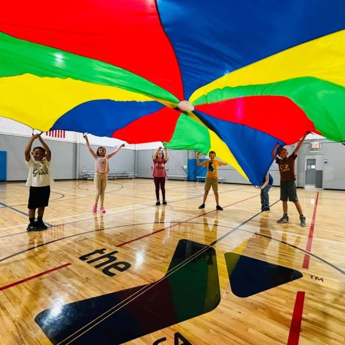 Students in the Williams Family YMCA's Homeschool PE program play a parachute game together. Photo by Emily Delaney