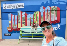 Lindsay Brown and her dog, Cooper, pose in front of the new mural outside Hurricane Grill & Wings in Julington Creek. Photo by Lindsay Brown