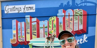Lindsay Brown and her dog, Cooper, pose in front of the new mural outside Hurricane Grill & Wings in Julington Creek. Photo by Lindsay Brown