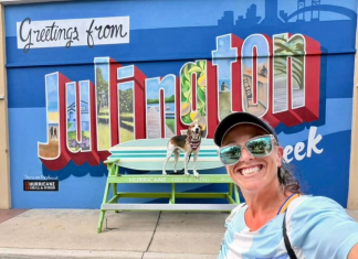 New Mural, New Era: Julington Creek restaurant’s makeover comes ahead of employee fundraiser Lindsay Brown and her dog, Cooper, pose in front of the new mural outside Hurricane Grill & Wings in Julington Creek. Photo by Lindsay Brown