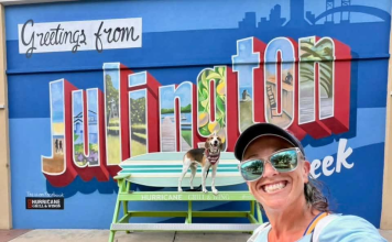 Lindsay Brown and her dog, Cooper, pose in front of the new mural outside Hurricane Grill & Wings in Julington Creek. Photo by Lindsay Brown