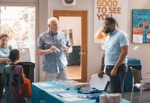 A member speaks with a First Coast YMCA staff member at a health and wellness table. Photo courtesy First Coast YMCA