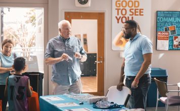 A member speaks with a First Coast YMCA staff member at a health and wellness table. Photo courtesy First Coast YMCA